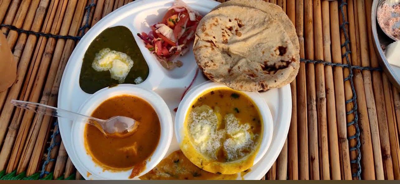 Traditional Indian thali meal with dal, saag, curry and fresh roti served at Sampada Village